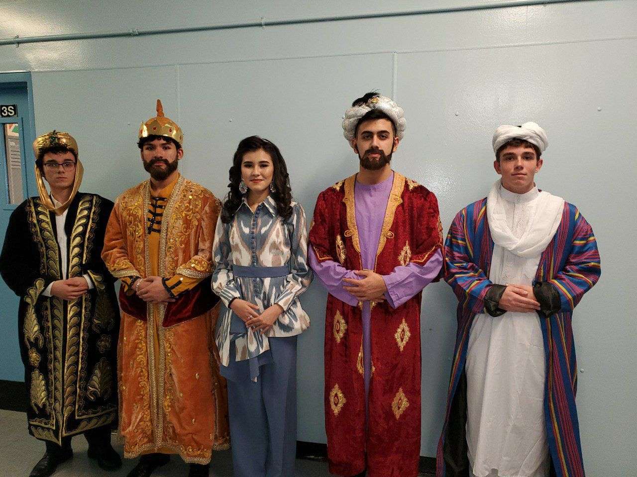 Performers costumed as historical figures in robes and crowns