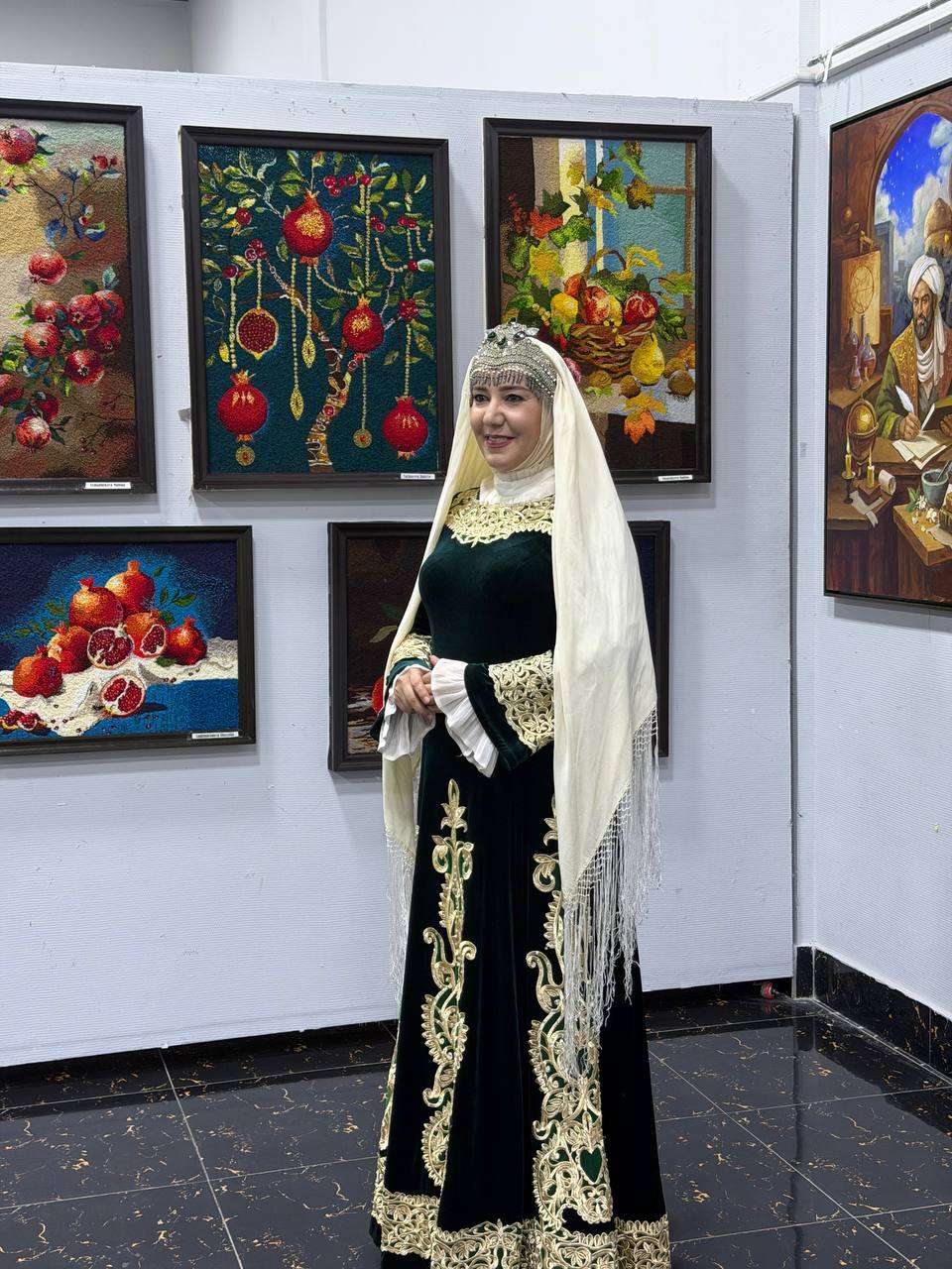 Woman in embroidered traditional dress and veil beside still-life paintings