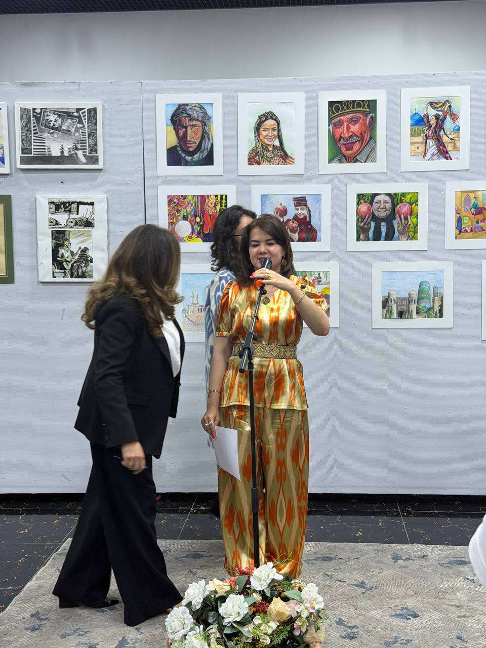 Guest in a shimmering gown beside a wall of framed photographs at an exhibition