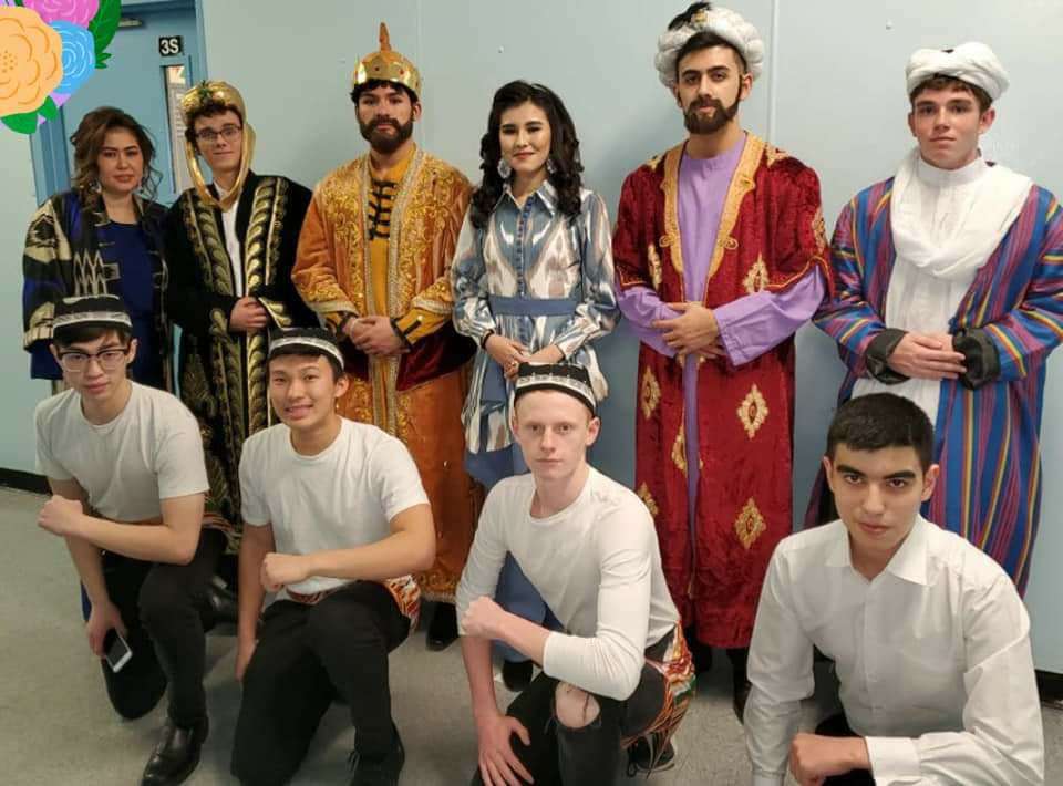 Young performers in historical costume posing with friends