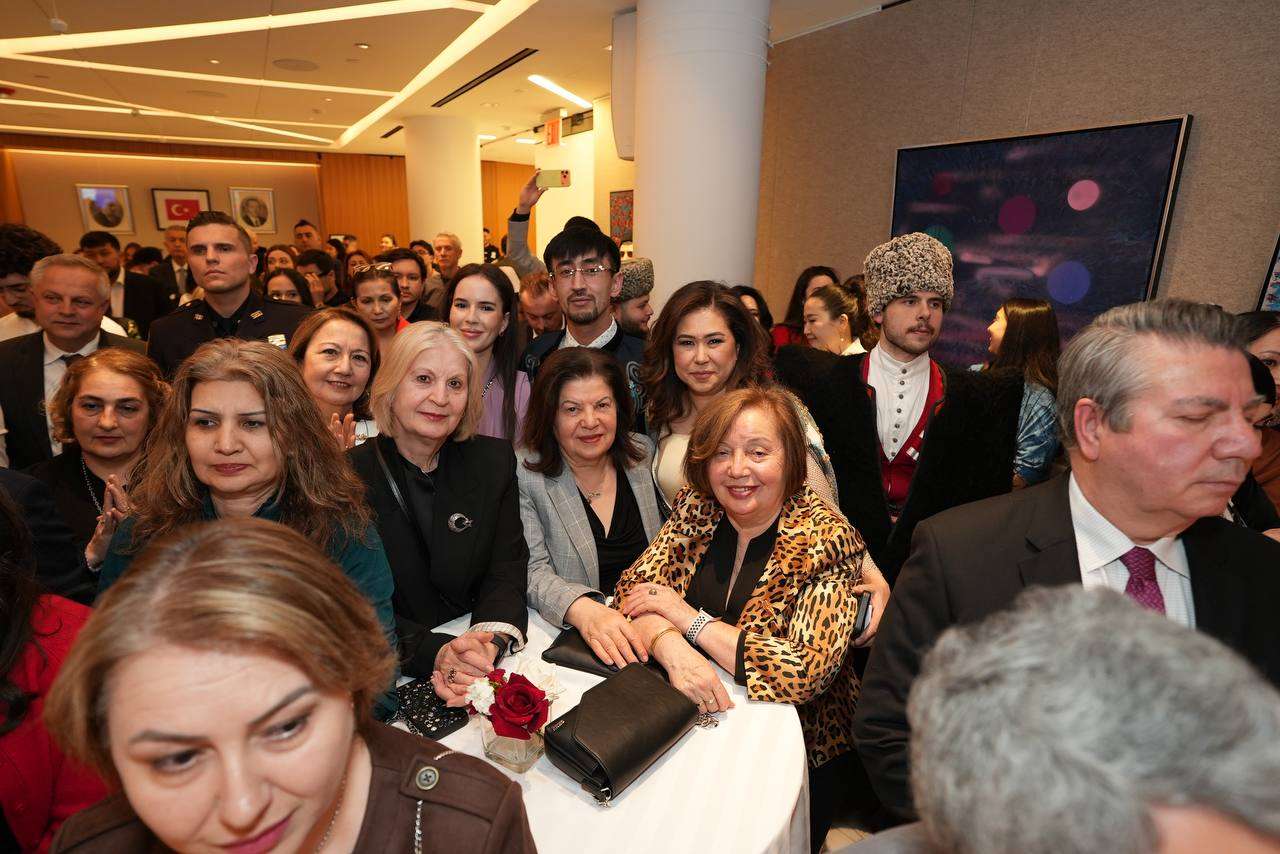 Audience seated closely at a well-attended community reception