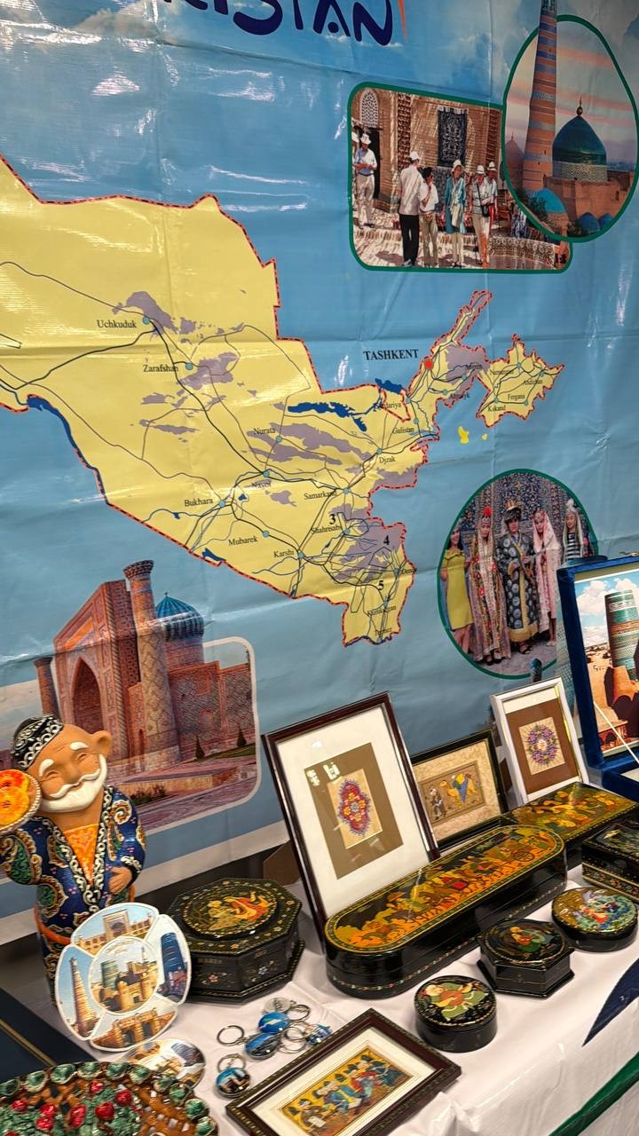Display of crafts and photographs arranged beneath a map of Uzbekistan